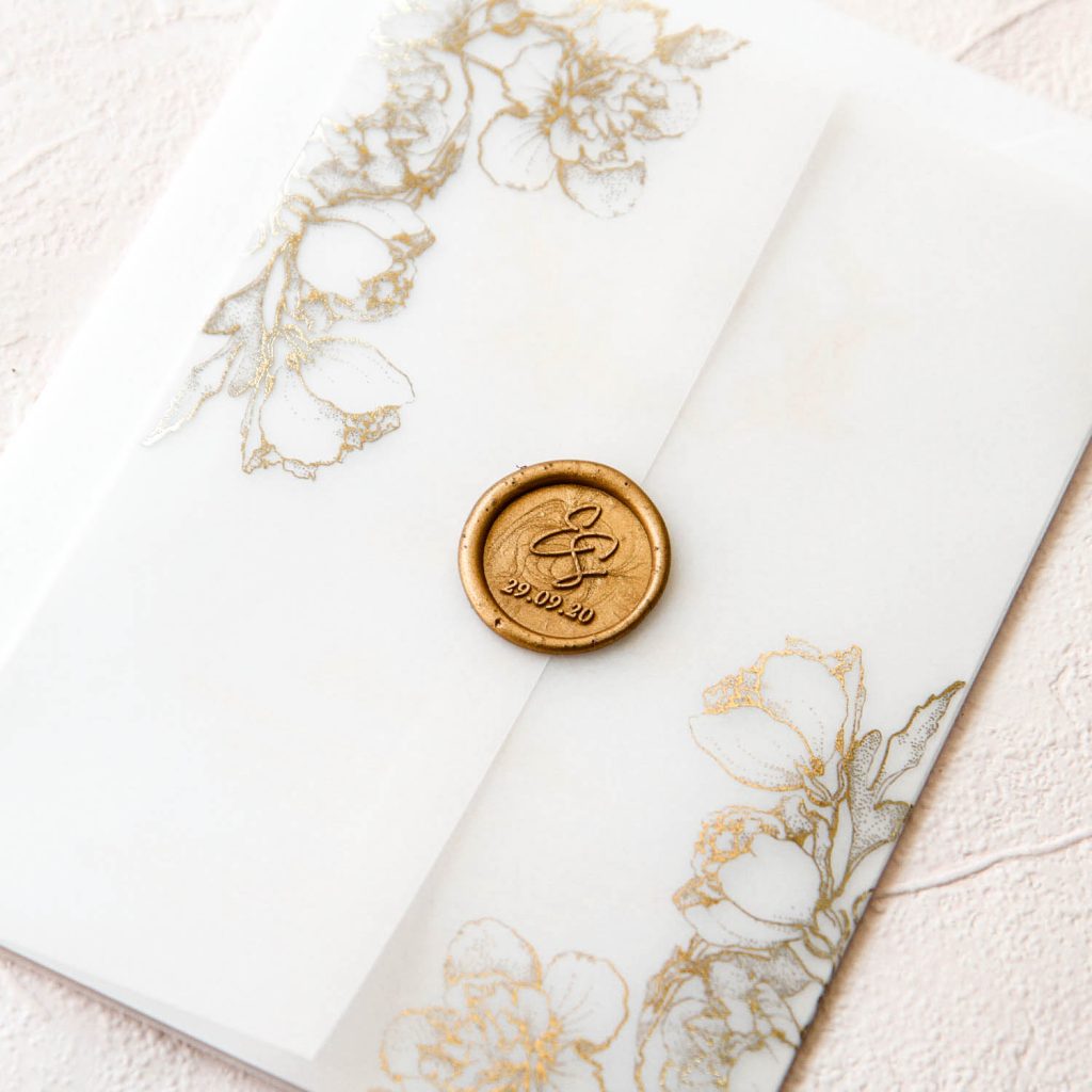 Gold foil vellum wrap invitation with delicate flowers